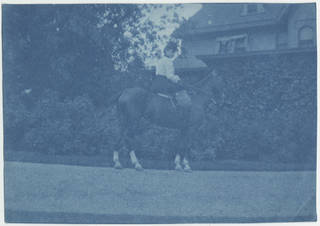 Slightly faded cyanotype photograph of a woman on a horse