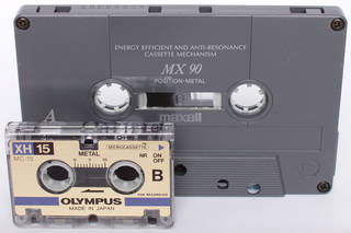 Microcassette against a compact cassette displaying difference in scale